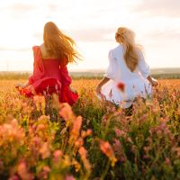 Two Beautiful woman in a field. Nature, fashion, vacation and lifestyle.